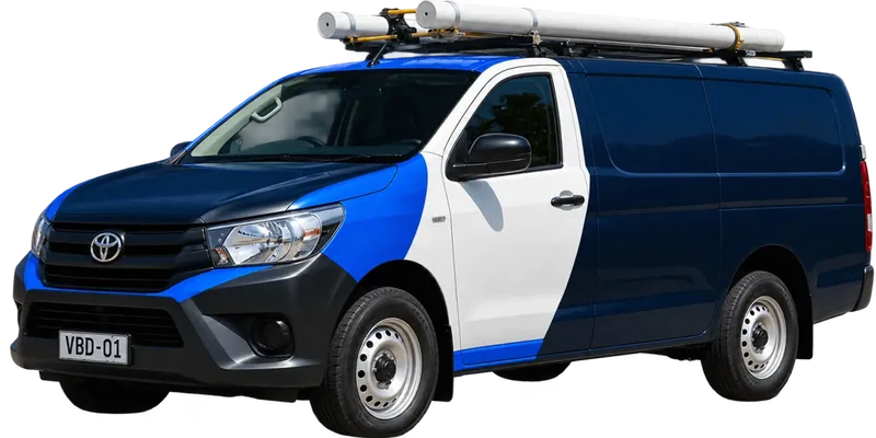 A licensed Ryde plumbing van loaded with pipe on the roof rack